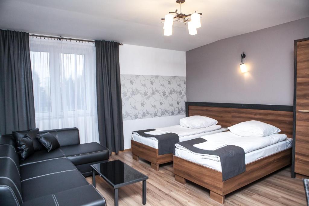 una camera d'albergo con due letti e un divano di Hotel Bukowiec a Legionowo