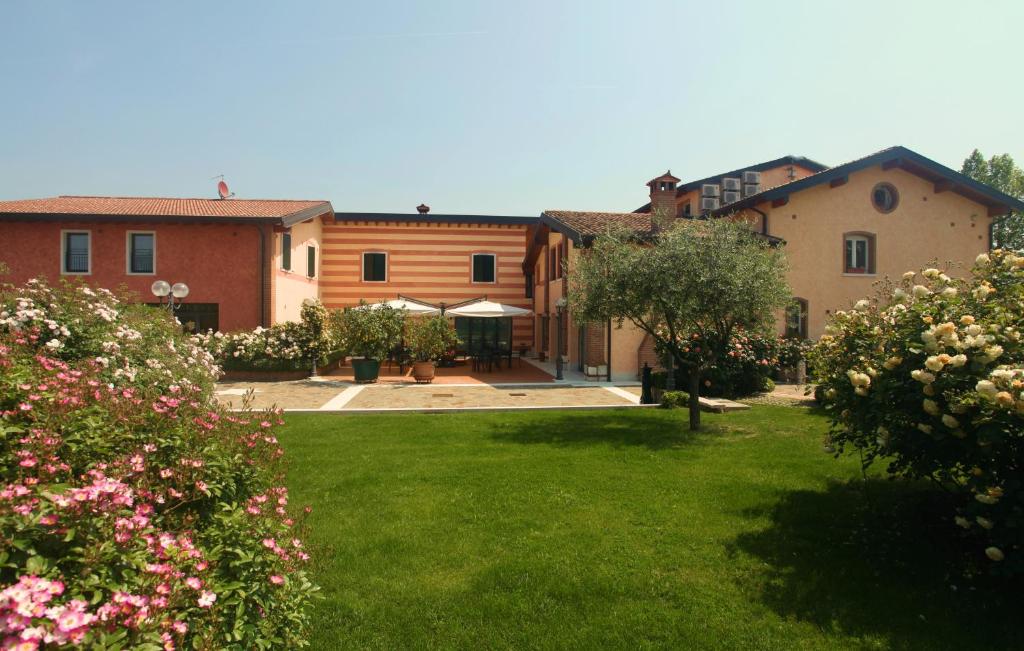 un gruppo di edifici in un cortile fiorito di Casa San Marco a Castelnuovo del Garda