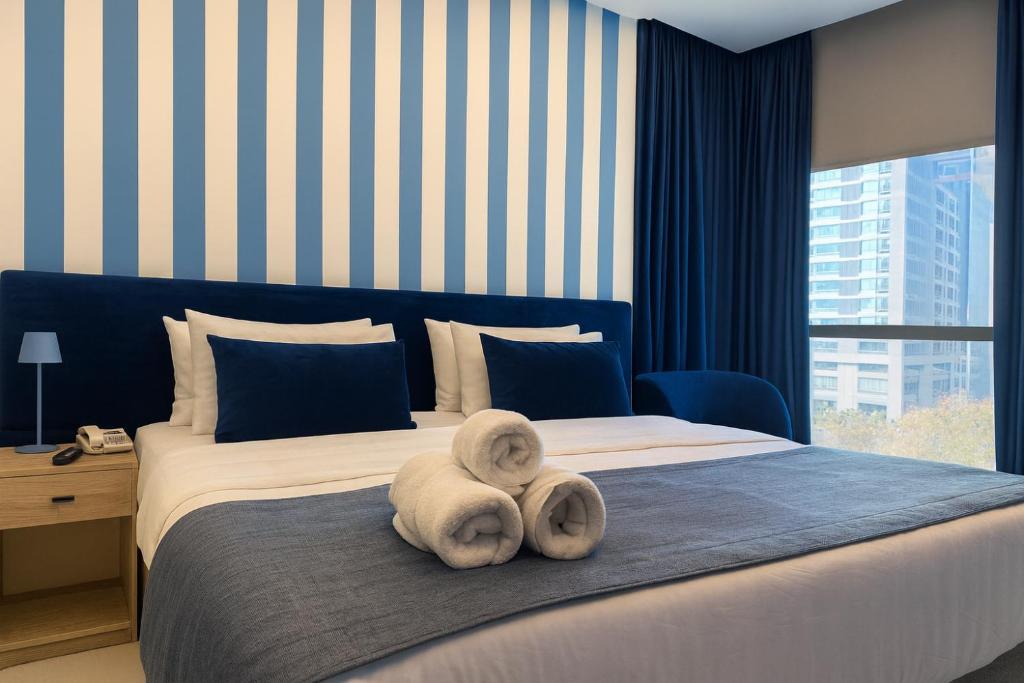 a bedroom with a large bed with towels on it at Shade Suites & Studios in Beirut