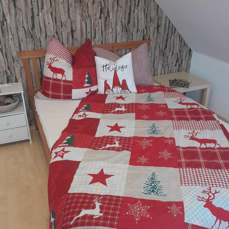 a bed with a christmas quilt on it at Taurasteinblick in Burgstaedt