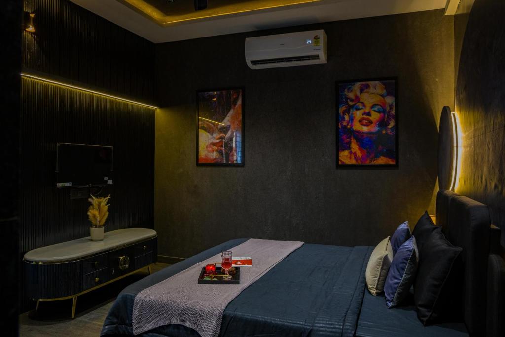 Dormitorio con cama, lavabo y pintura en Ayush villa, en Udaipur