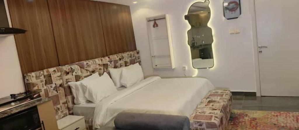 um quarto com uma grande cama branca em um quarto em Mcangello apartments em Idimu