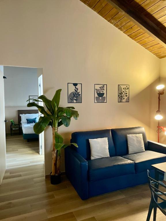 a living room with a blue couch and a bedroom at Bnbook Residence Matteotti in Novara
