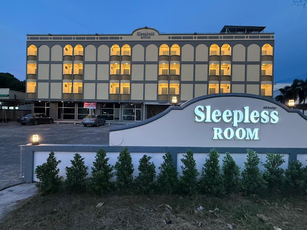 a hotel with a sign in front of a building at SLEEPLESS ROOM Phitsanulok in Sathani Phitsanulok