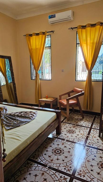 a room with two beds and two windows at ZanziBalkan House Nungwi in Nungwi