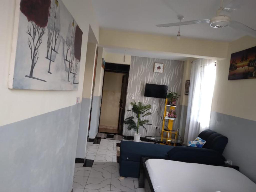 a living room with a blue couch and a room with a window at House 139 Vescon one in Roka