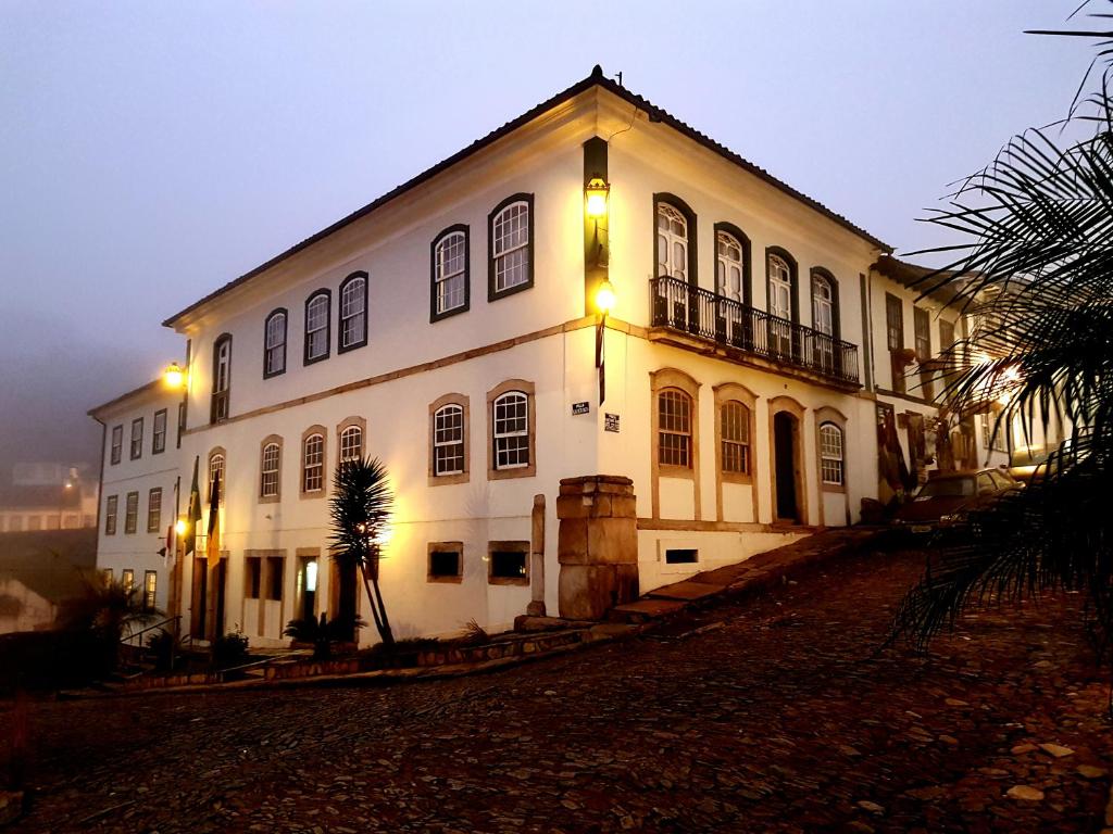 a large white building with lights on it at night at Hotel Luxor in Ouro Preto