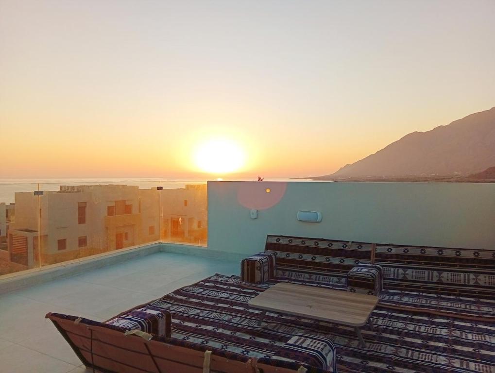 ein Swimmingpool mit einem Sonnenuntergang im Hintergrund in der Unterkunft SifahSeaSun in As Sīfah