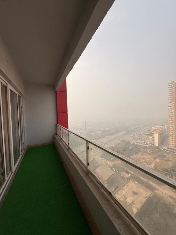 a balcony with green flooring and a view of a city at Your own bnb in Ghaziabad