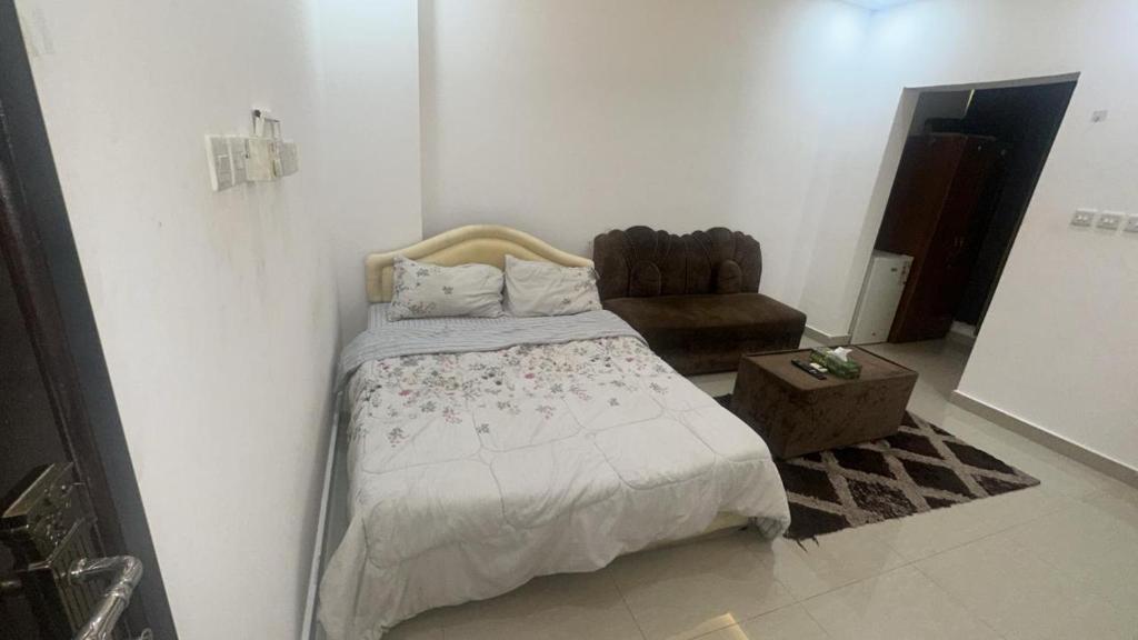 ein Schlafzimmer mit einem Bett und einem Stuhl in einem Zimmer in der Unterkunft Raha rooms in Seeb