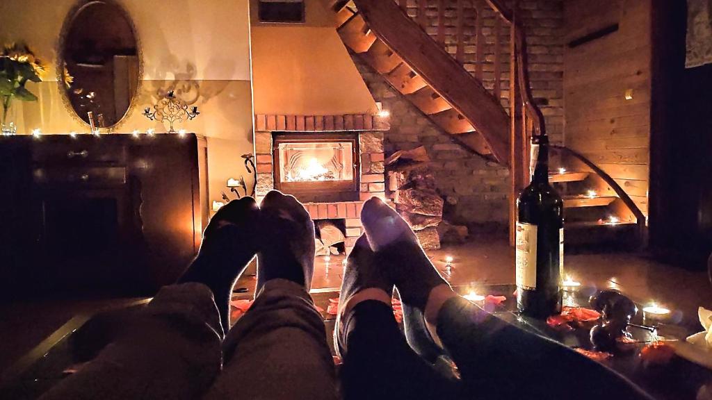 a person with their feet up in front of a fireplace at Dom ukryty przed światem - Szeroki Bór in Ruciane-Nida