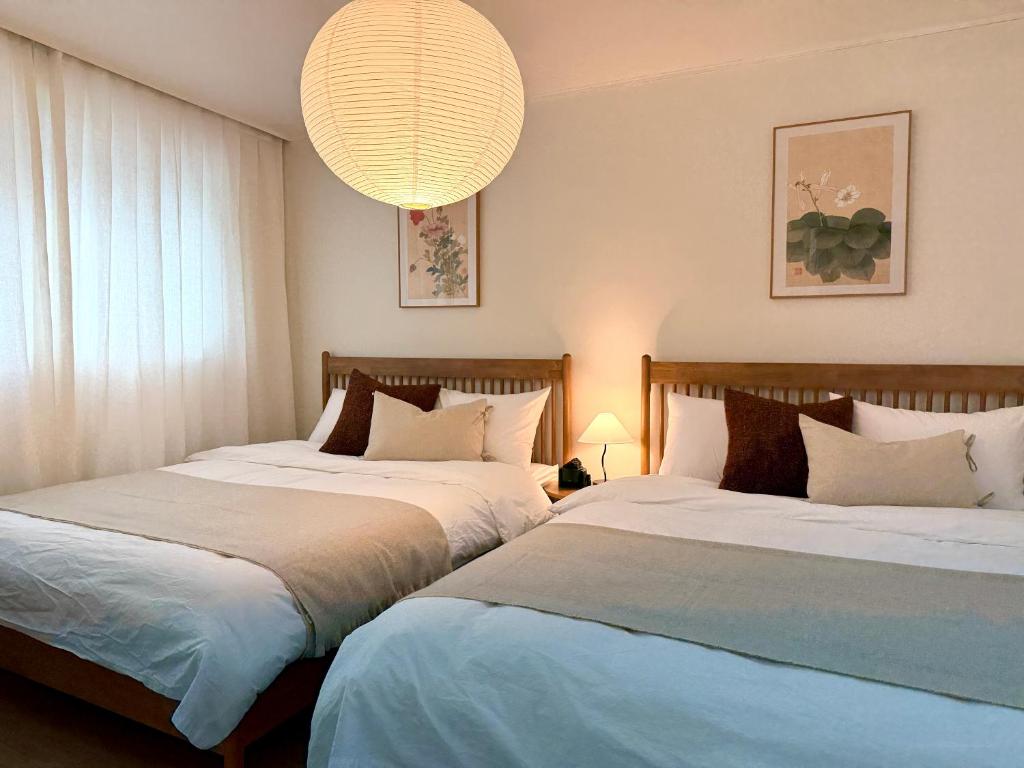 zwei nebeneinander stehende Betten in einem Schlafzimmer in der Unterkunft NEW Stay Rombus in Seoul