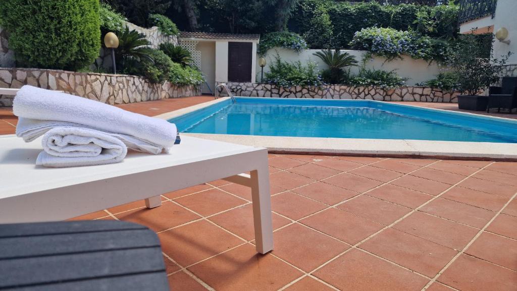 un asciugamano seduto su una panchina accanto alla piscina di Villa Domus Dea Mondello a Palermo