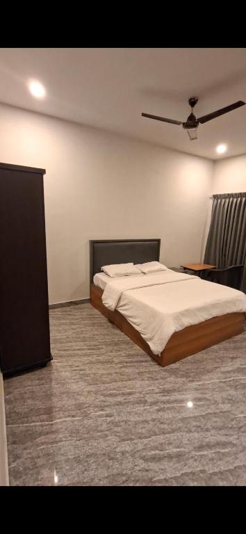 ein Schlafzimmer mit einem großen Bett in einem Zimmer in der Unterkunft Tkt Tourist Home in Kannur