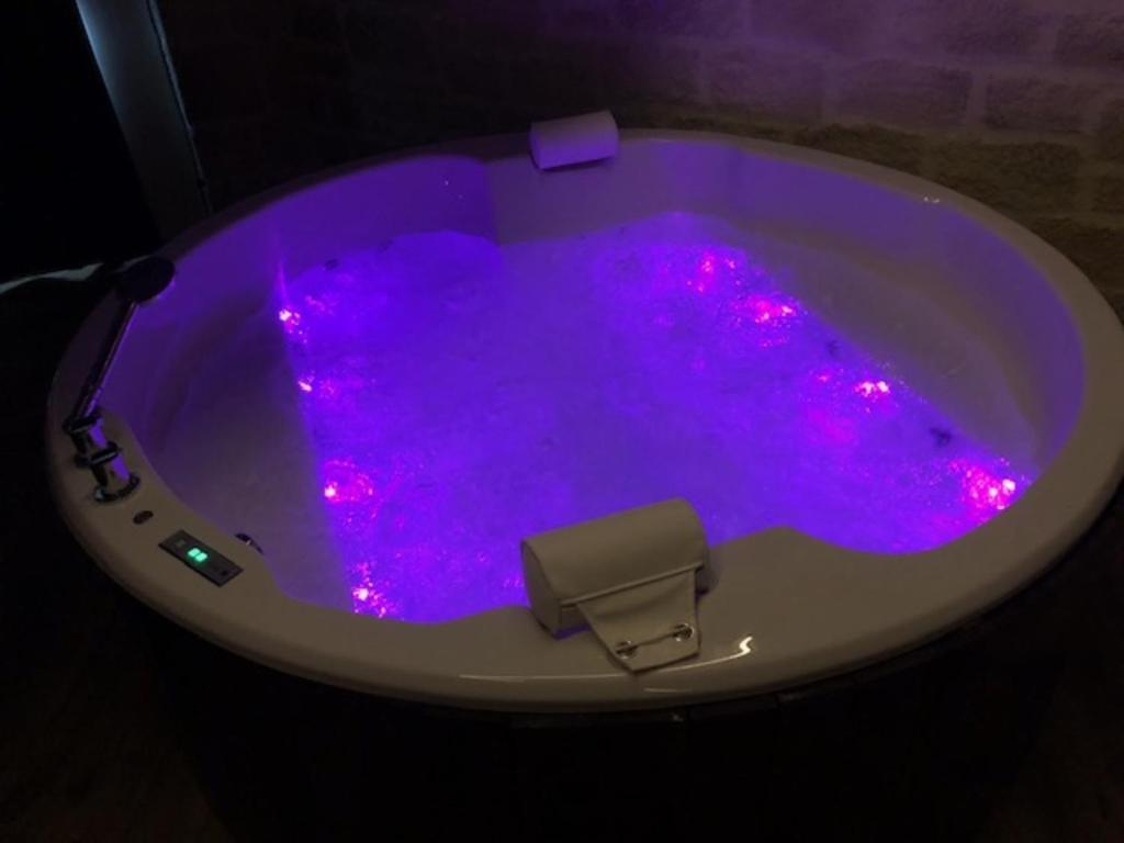 Una bañera morada con luces rosas. en La voûte des Baous, en Vence