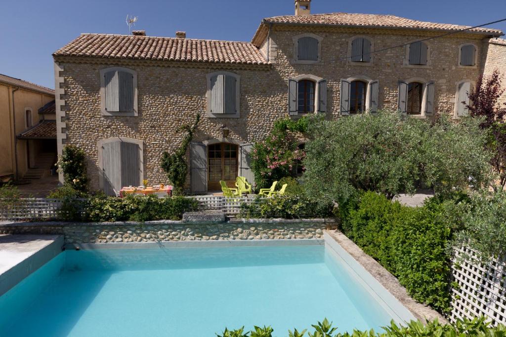 a villa with a swimming pool in front of a house at Clos Du Père Clément in Visan
