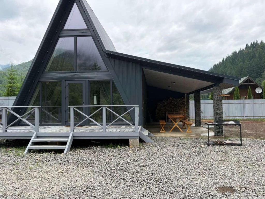 a house with a roof with a bench and a table at Frame&Forest in Kolochava