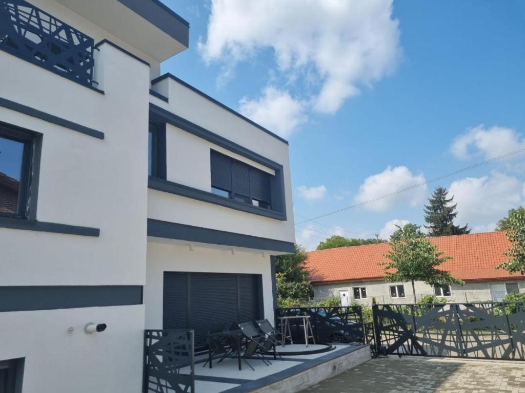 a white house with chairs on a patio at Georgiana Apartments 2 in Timişoara