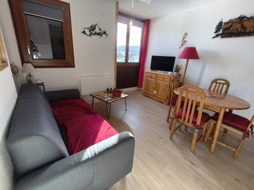 una sala de estar con un sofá y una mesa en T2 cosy à Puyvalador - Ski & lac, en Puyvalador