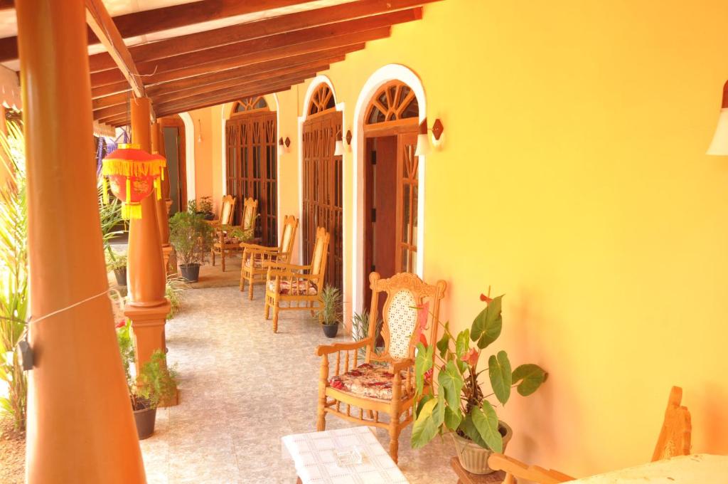 a porch of a house with chairs and tables at Sigiri Sara Home Stay Nice Village in Sigiriya