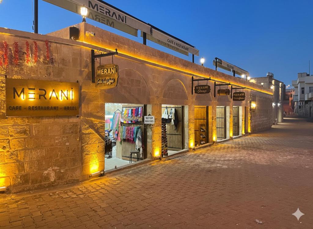 una fila di negozi in una strada di notte di Merani Hotel a Midyat
