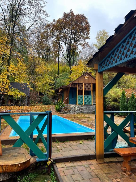 a swimming pool with a gate and a house at FoRResT in Chynadiyovo