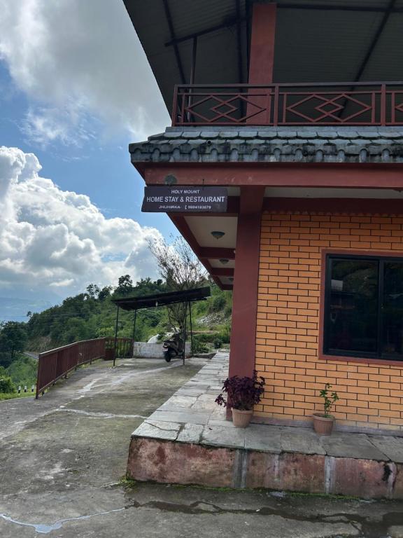 Un edificio con un cartel al costado. en Holy mount home stay, en Astam