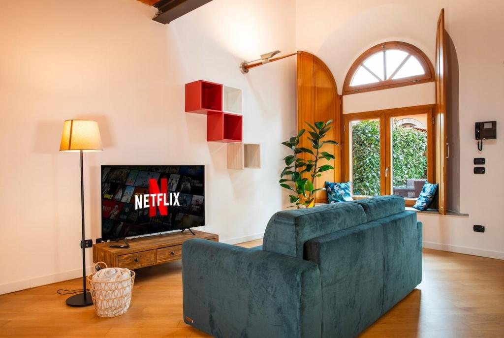 TV a/nebo společenská místnost v ubytování Casa di design con giardino privato in Centro a PIACENZA