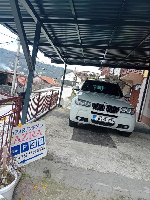 a white bmw car parked under a garage at Apartments AZRA in Konjic