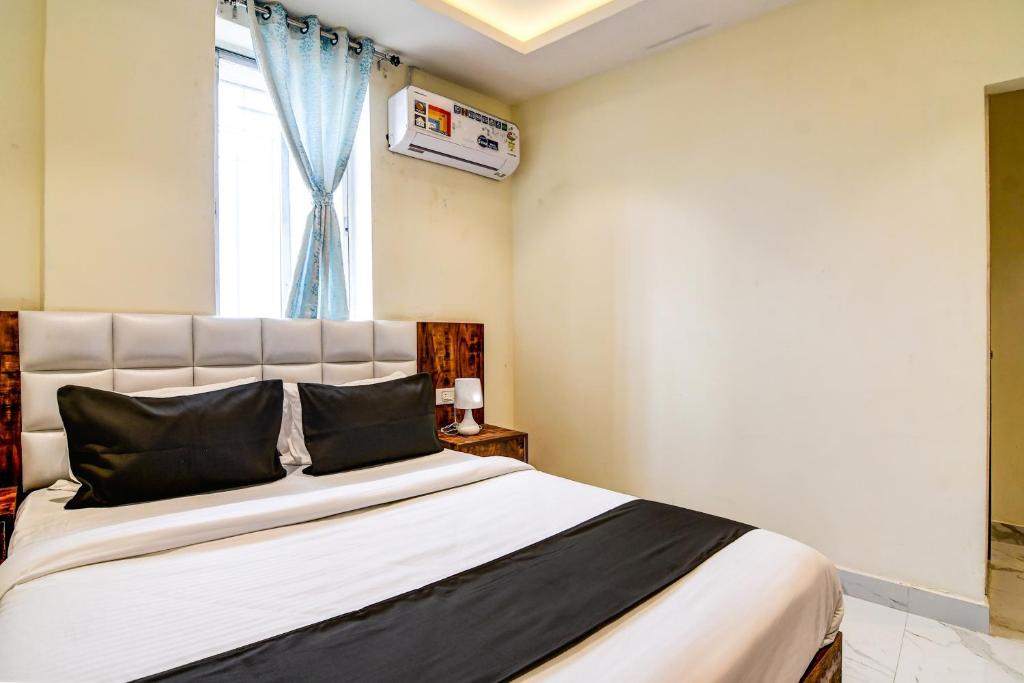 Un pat sau paturi într-o cameră la Collection O The Hastings Club