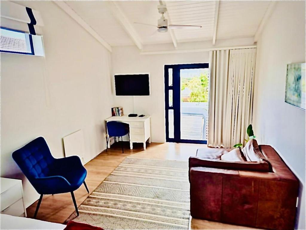 een woonkamer met een bank, een stoel en een bureau bij KommRust in Kommetjie