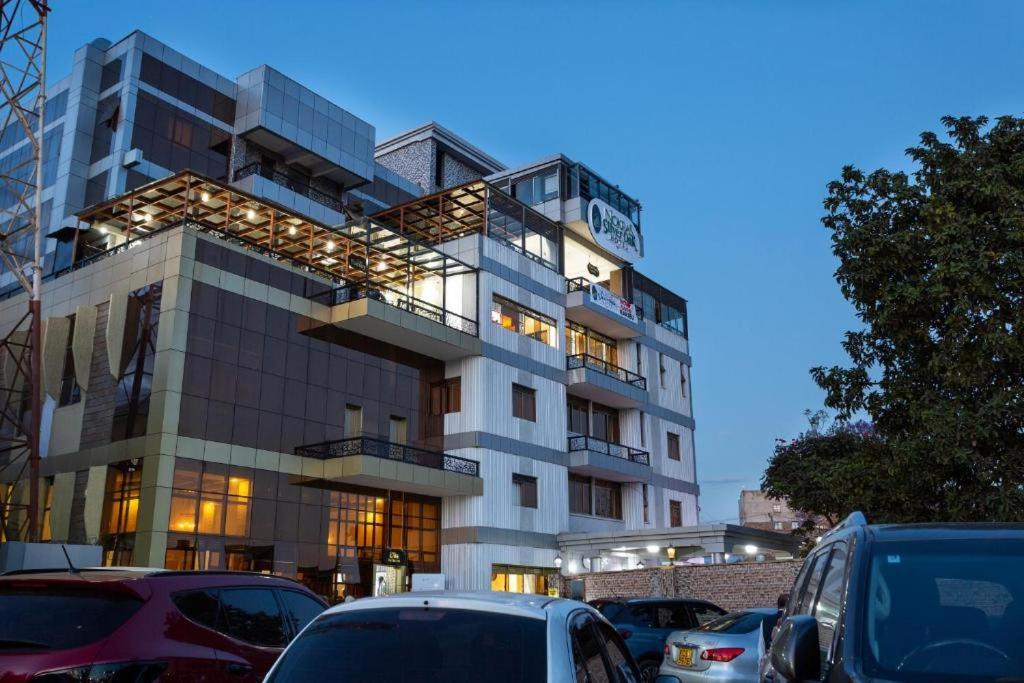 Un edificio con coches aparcados delante. en Nokras SilverOak Hotel, Embu, en Embu