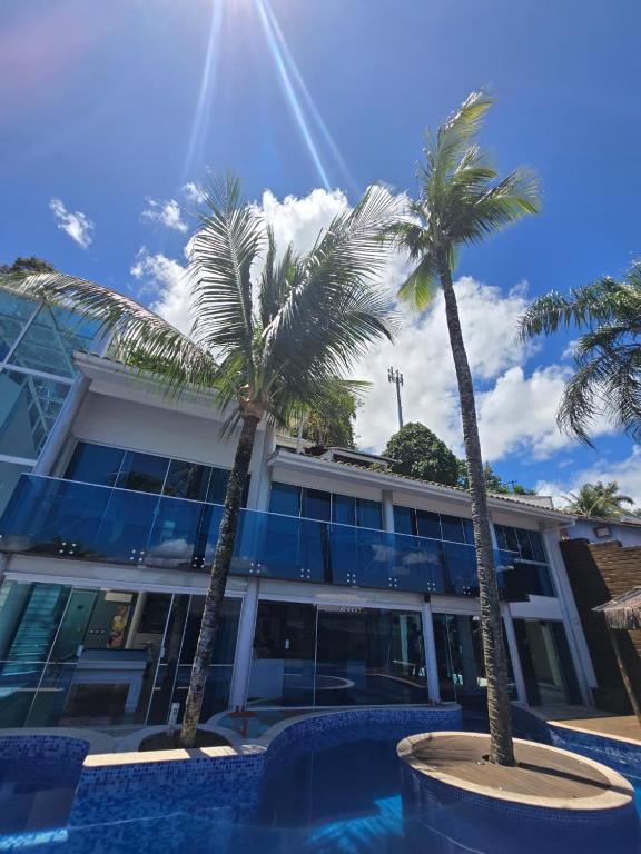 two palm trees in front of a building at Residência Angra Deep Blue in Angra dos Reis