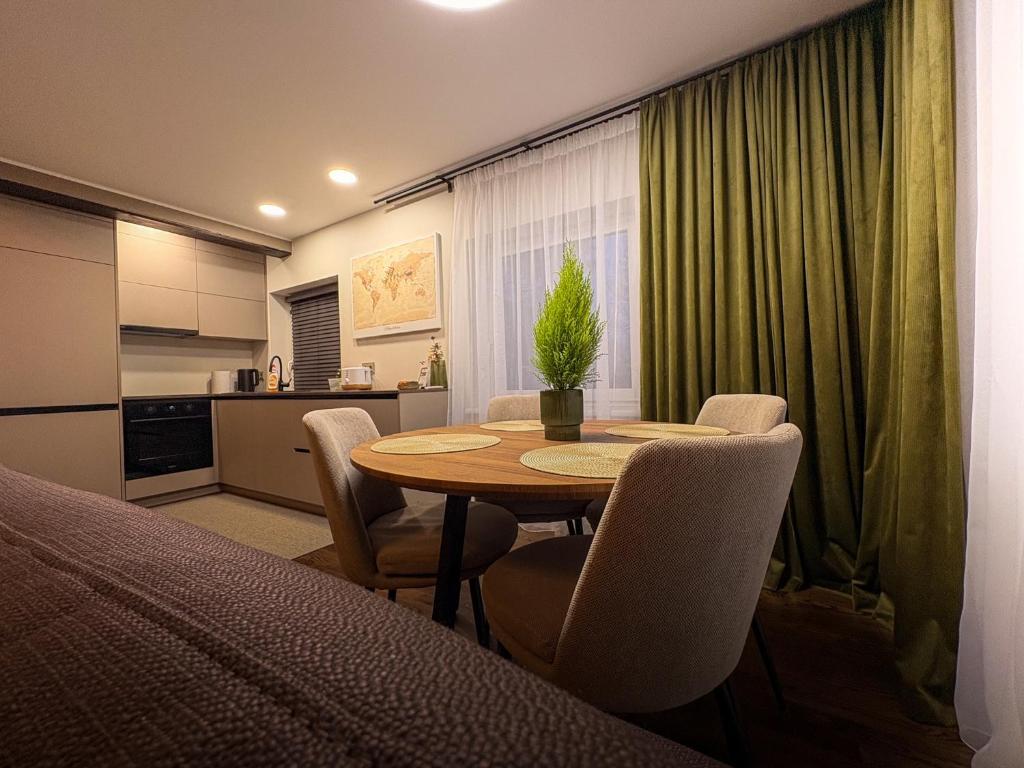 a room with a table and chairs and a kitchen at Telšiai Modern Central Apartments in Telšiai