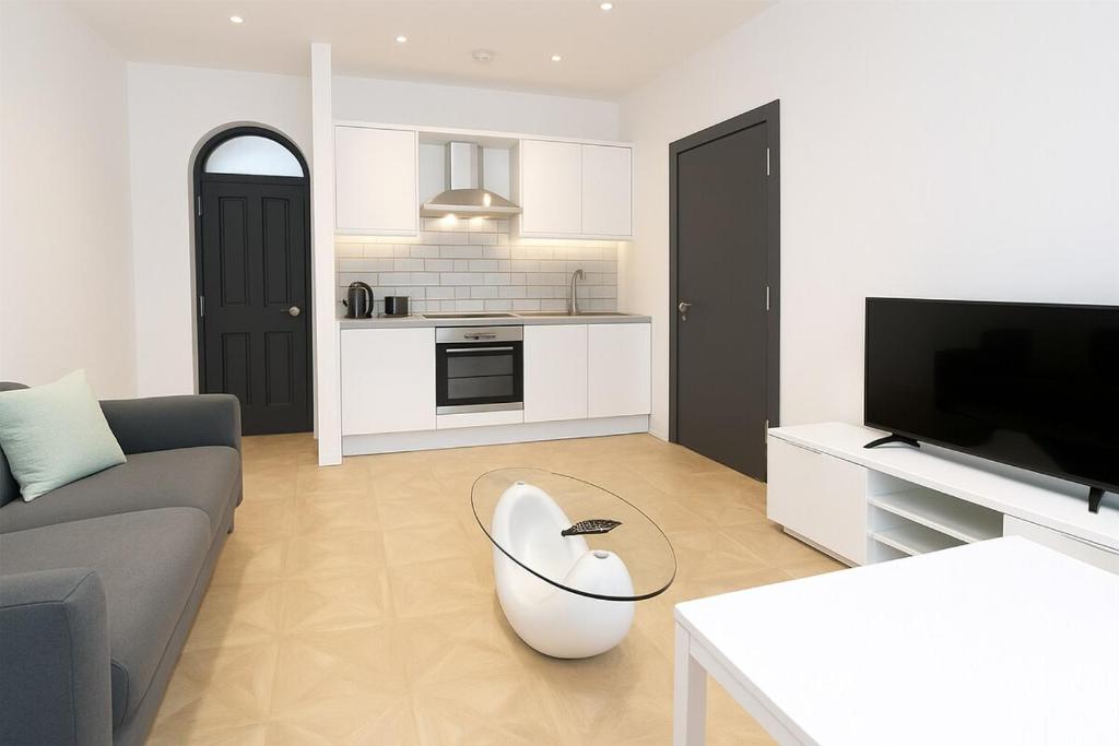 uma sala de estar com um sofá e uma mesa em Leeds Central Cosy 1BD Flat 10 mins to Station! em Leeds