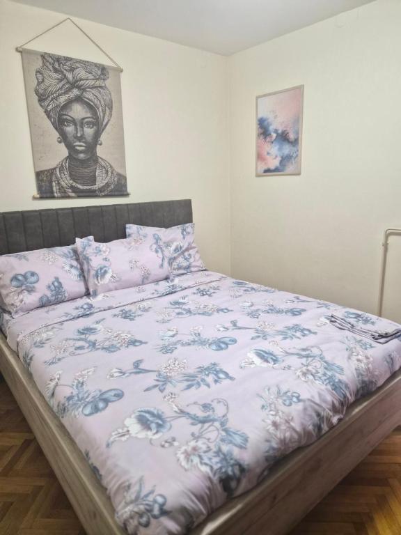 sypialnia z łóżkiem z niebiesko-białą kołdrą w obiekcie Apartman I&V w mieście Vrnjačka Banja