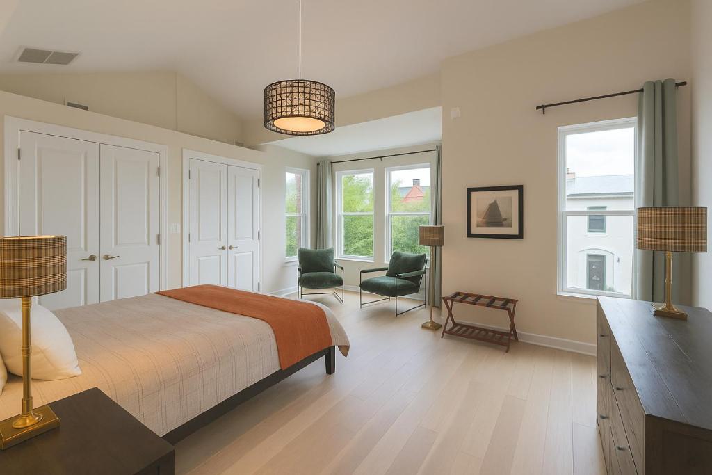 a bedroom with a bed and a chair and windows at Modern 1 block from Metro subway Minutes to Capital, Museums and National Mall in Washington