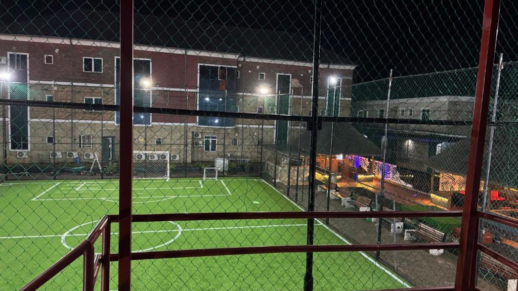 a tennis court at night with a tennis court at Axion Hotel in Owerri