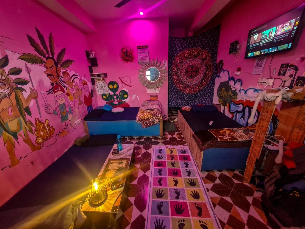 The Rawscape hostel في كاوساني: غرفة معيشة بجدران وردية اللون وغرفة بها طاولة