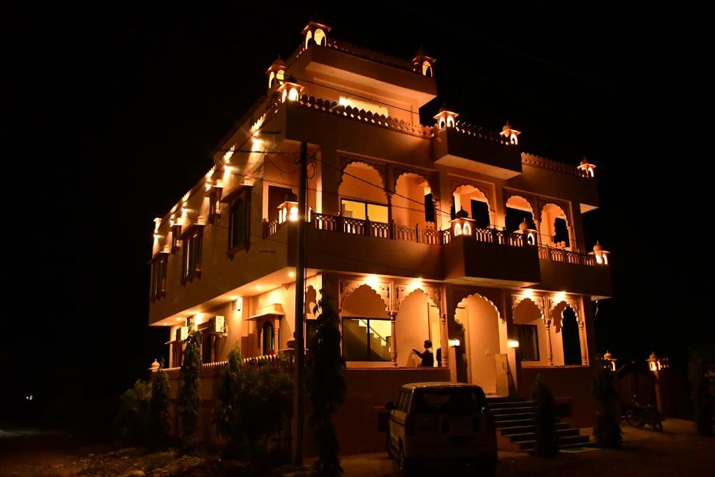 een groot gebouw met 's nachts verlichting bij The Vantage Haveli in Sawāi Mādhopur