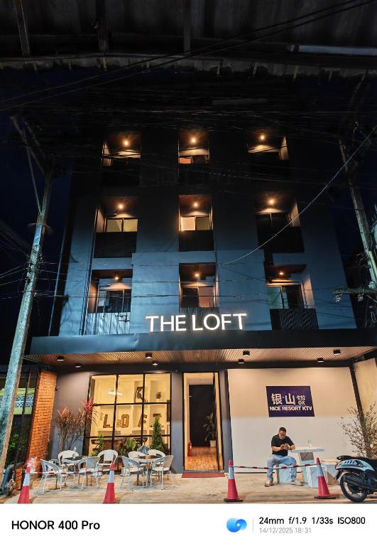 a person sitting on a bench in front of a building at The loft hotel Betong in Betong