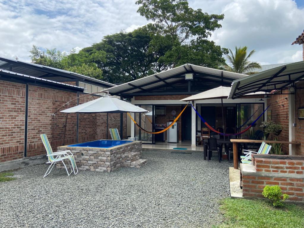 un patio con una mesa y una sombrilla en Cabaña el Anhelo, en Ginebra
