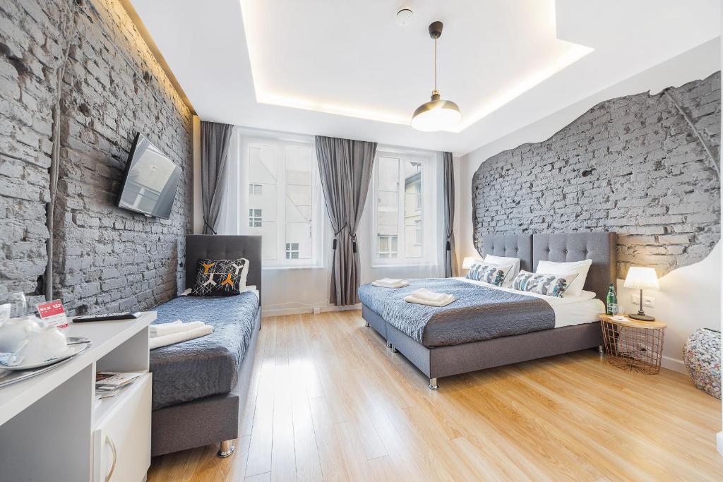 a bedroom with a bed and a stone wall at Six Suites, Old Town in Gdańsk