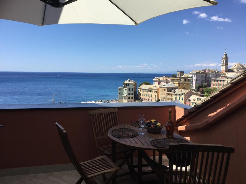 uma mesa e cadeiras numa varanda com vista para o oceano em La Mansarda Sul Mare em Bogliasco