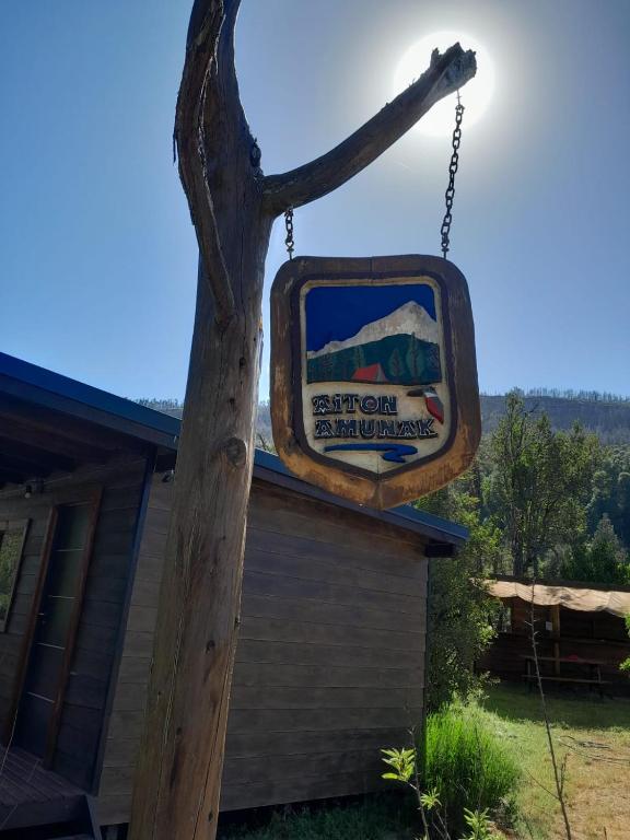 a mirror hanging on a pole next to a house at Camping Aiton Amunak in El Bolsón