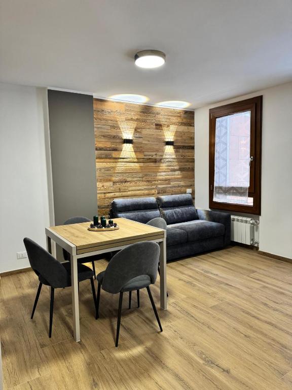 a living room with a couch and a table and chairs at Cima Bianca Suite in Passo del Tonale