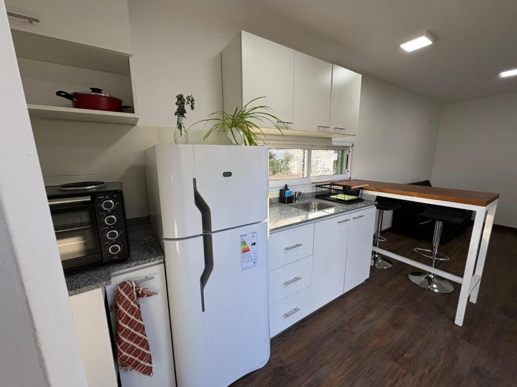 een keuken met een witte koelkast en een tafel bij Karü in Aluminé