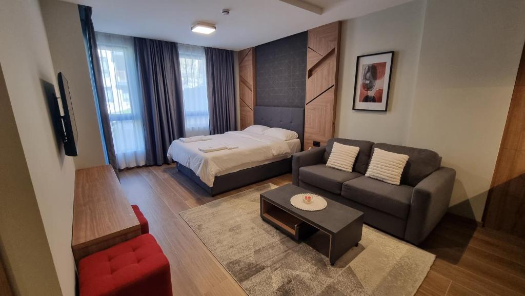 Habitación pequeña con cama, sofá, cama y sofá en Apartman LUX Tarski san, en Kaludjerske Bare