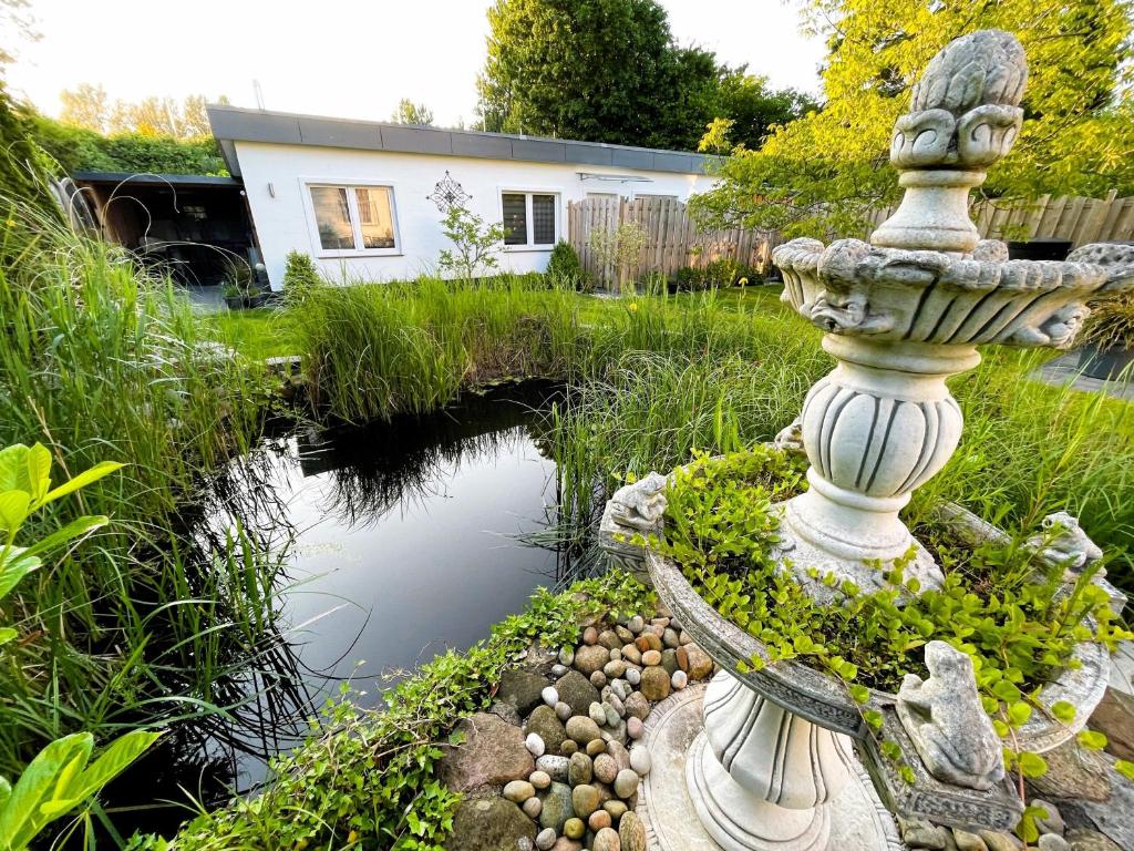 a garden with a statue next to a pond at Ferienhaus Stamer in Eckernförde