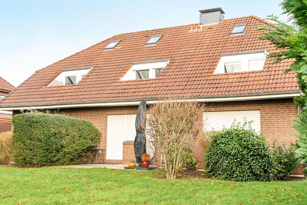 ein rotes Backsteinhaus mit einem roten Dach in der Unterkunft Meeresfeeling in Horumersiel in Horumersiel